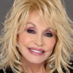Dolly Parton age biography image featuring a close-up portrait with blonde hair and a soft grey background.
